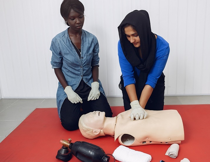 Medical students are practicing. Ladys provide first aid. Women in medical gloves performs resuscitation.